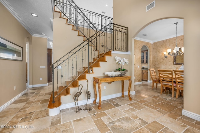 stairway with crown molding, a textured ceiling, and a notable chandelier