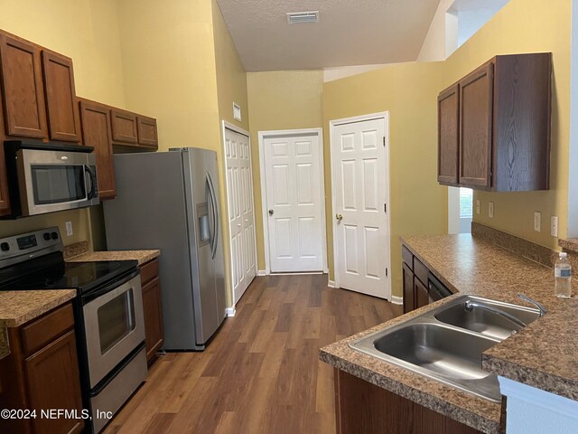 kitchen with visible vents, dark wood-style floors, appliances with stainless steel finishes, a textured ceiling, and a sink