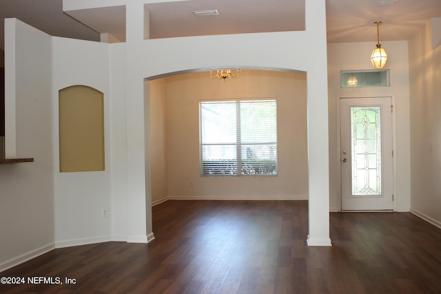 foyer featuring baseboards, wood finished floors, and a healthy amount of sunlight