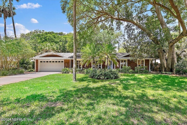 ranch-style house with a garage and a front lawn