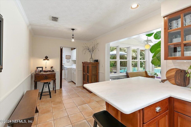 kitchen with pendant lighting, light tile patterned floors, ceiling fan, crown molding, and a textured ceiling