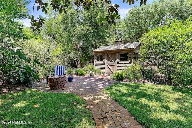 view of yard with an outdoor fire pit and an outdoor structure