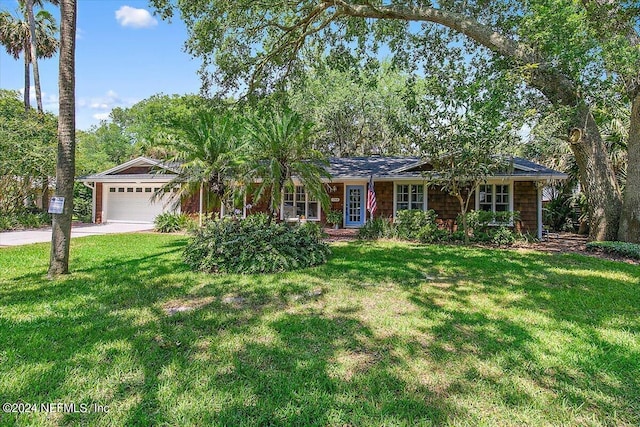 ranch-style home with a garage, a front lawn, and concrete driveway