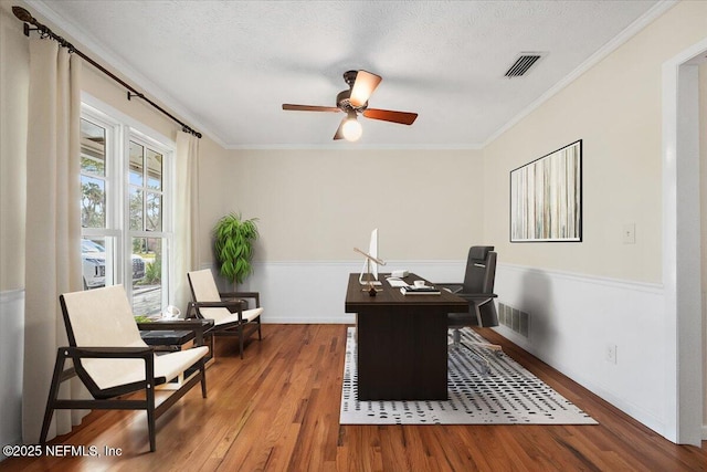 office with ornamental molding, visible vents, a textured ceiling, and wood finished floors