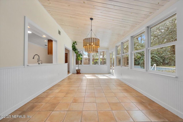 unfurnished sunroom featuring lofted ceiling, sink, wooden ceiling, and a chandelier