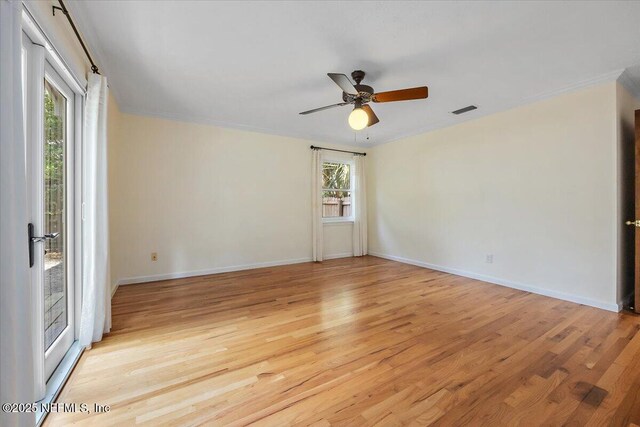 spare room featuring ceiling fan, a wealth of natural light, and light wood-type flooring