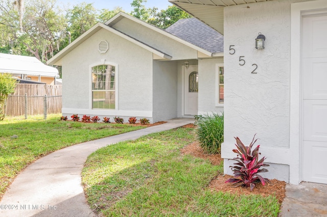 doorway to property with a yard