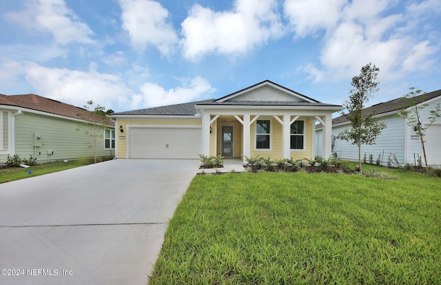 view of front of property featuring a porch, a garage, and a front lawn