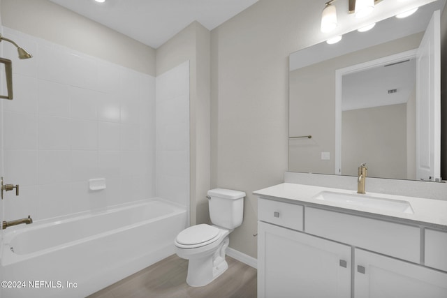 full bathroom with toilet, tiled shower / bath combo, vanity, and hardwood / wood-style floors