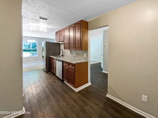 kitchen featuring sink, appliances with stainless steel finishes, dark hardwood / wood-style flooring, and a textured ceiling