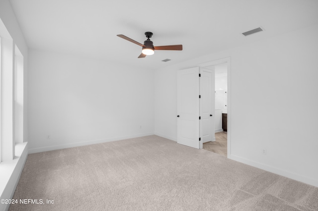 carpeted spare room with ceiling fan