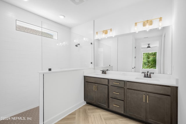 bathroom with ceiling fan, vanity, parquet flooring, and a tile shower