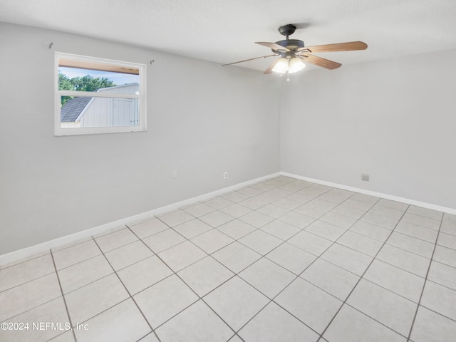 unfurnished room with ceiling fan and light tile floors