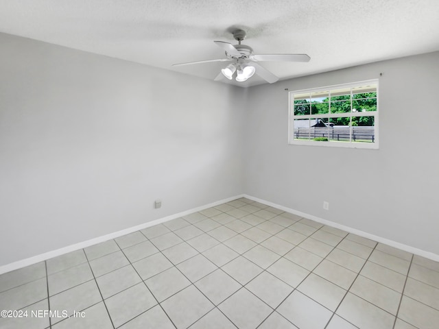 tiled spare room with ceiling fan and a textured ceiling