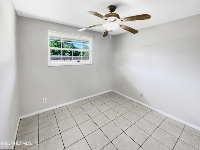 tiled spare room with ceiling fan