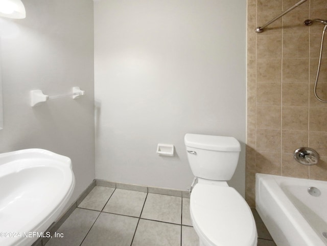 full bathroom featuring tile flooring, sink, tiled shower / bath, and toilet