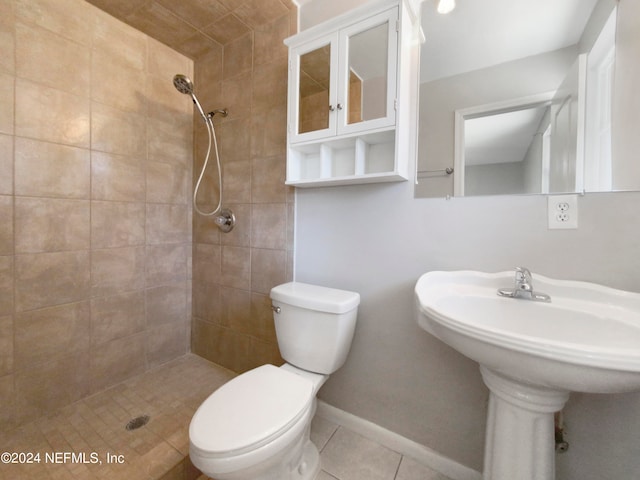 bathroom featuring tiled shower, toilet, and tile flooring