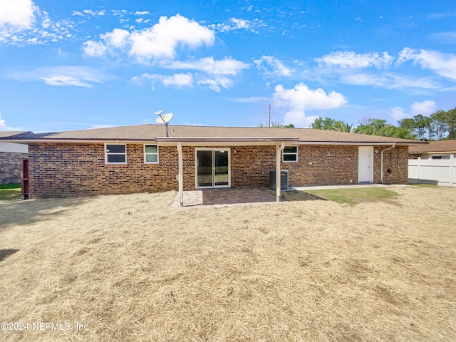 rear view of property with a patio area, a yard, and central air condition unit