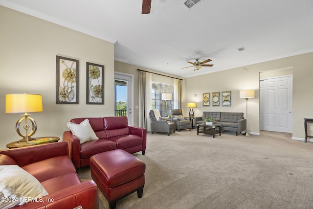 carpeted living room featuring crown molding and ceiling fan