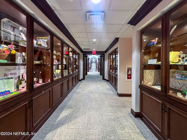 corridor with light carpet and a drop ceiling