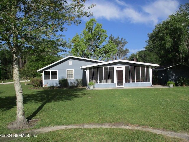 rear view of property with a yard and a sunroom