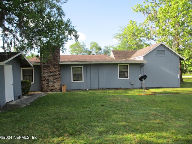 back of property featuring a lawn