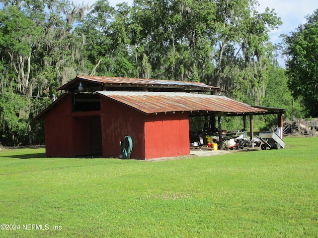 view of shed / structure with a carport and a lawn