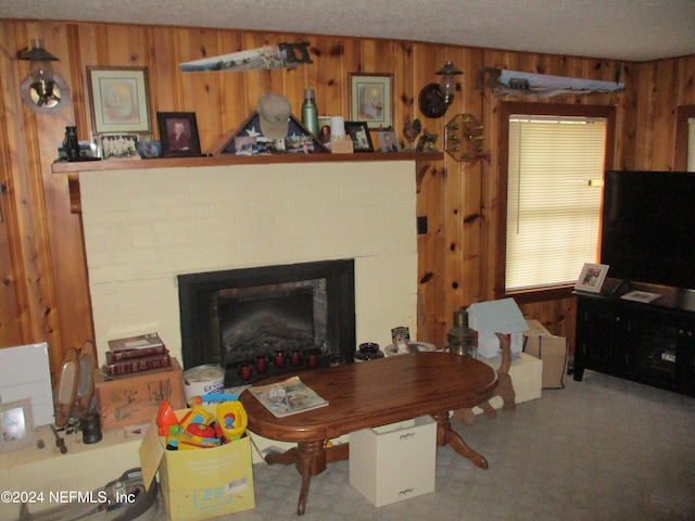 interior space with wood walls, a brick fireplace, and carpet floors