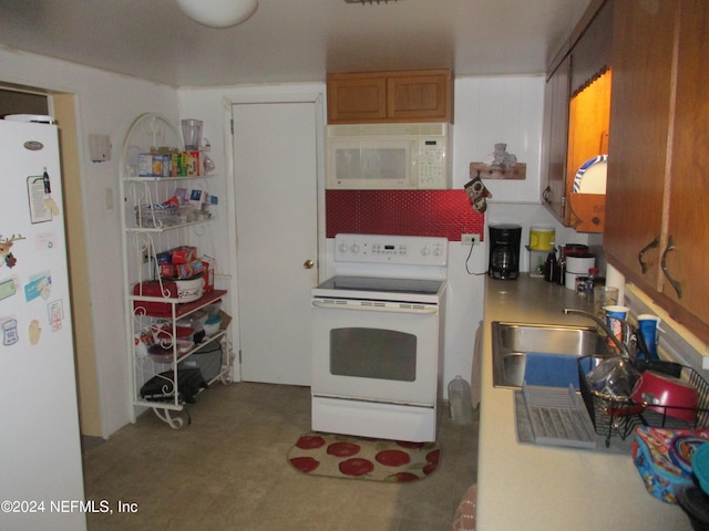 kitchen with white appliances, sink, and tile flooring