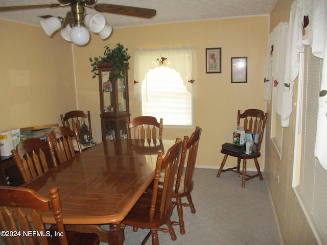 carpeted dining space featuring ceiling fan