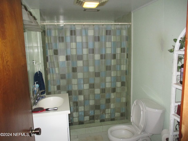 bathroom featuring toilet, tile flooring, and vanity