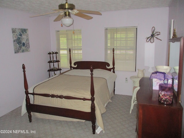 bedroom with ceiling fan, carpet floors, and multiple windows