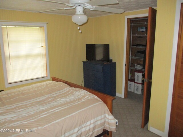 bedroom with carpet flooring, ceiling fan, a closet, and multiple windows