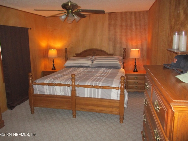 bedroom featuring ceiling fan and wood walls