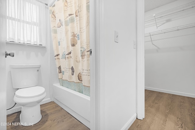 bathroom featuring toilet, shower / bathtub combination with curtain, and wood-type flooring