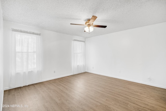 unfurnished room featuring hardwood / wood-style floors, a healthy amount of sunlight, and a textured ceiling