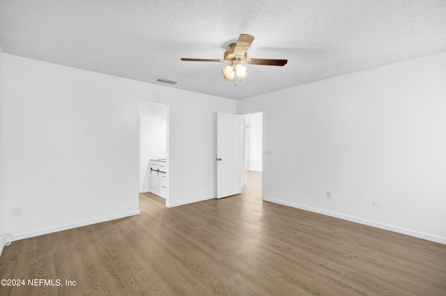 empty room featuring dark wood-type flooring, ceiling fan, and a textured ceiling