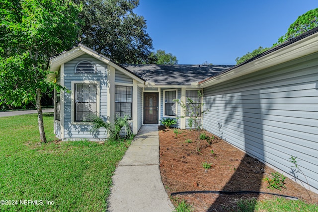 entrance to property featuring a yard