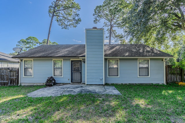 rear view of property with a patio area and a lawn