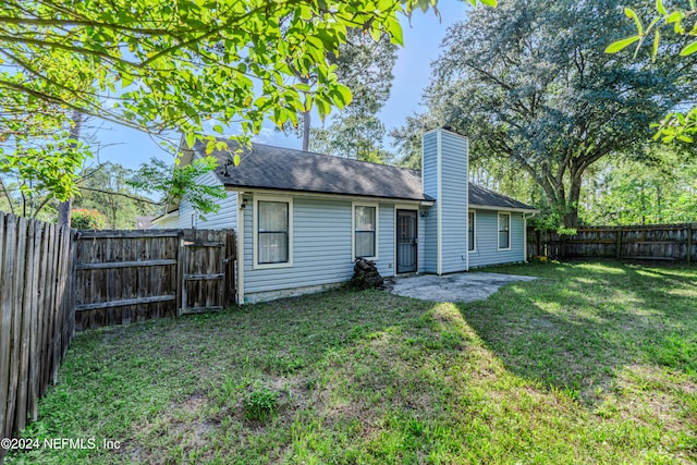 rear view of property with a lawn