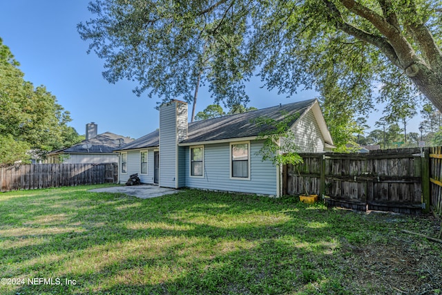 back of house featuring a patio and a yard