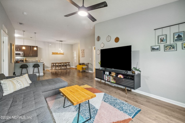 living room featuring light hardwood / wood-style flooring and ceiling fan