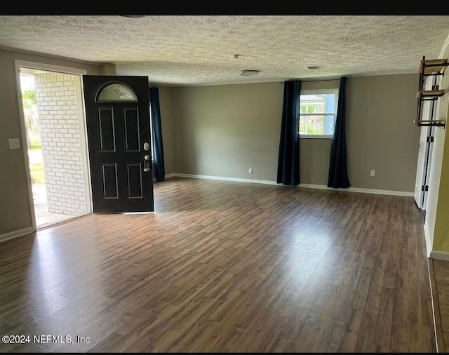 entrance foyer with a textured ceiling and dark hardwood / wood-style floors