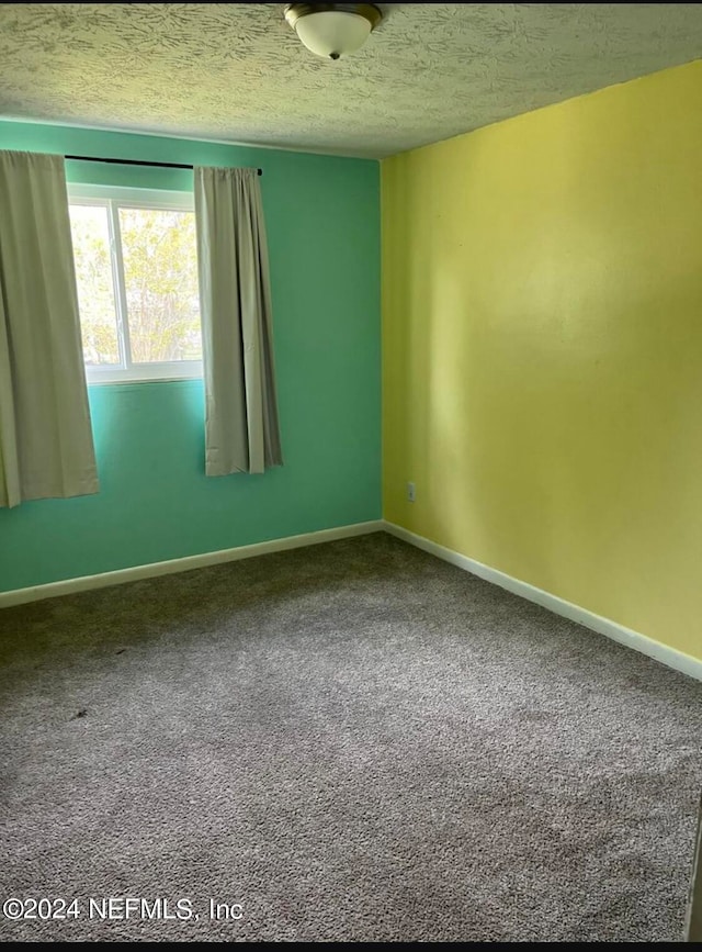 unfurnished room featuring a textured ceiling and carpet floors