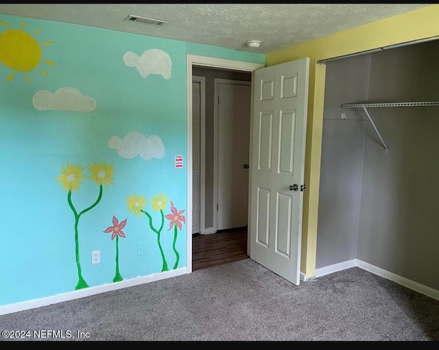 unfurnished bedroom featuring a textured ceiling, a closet, and carpet flooring