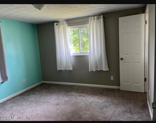 carpeted spare room featuring a textured ceiling