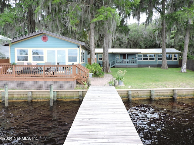 dock area featuring a yard and a deck with water view