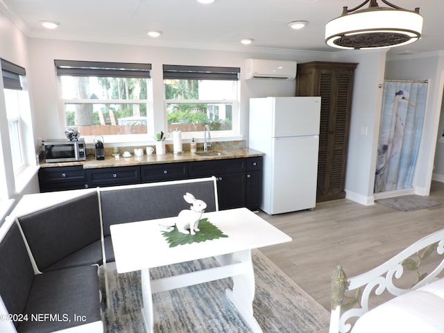 kitchen with sink, light hardwood / wood-style floors, a wall mounted AC, white refrigerator, and crown molding