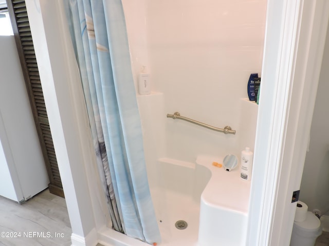 bathroom featuring walk in shower and hardwood / wood-style flooring