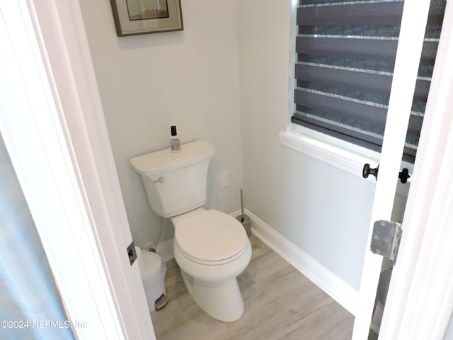 bathroom with hardwood / wood-style floors and toilet